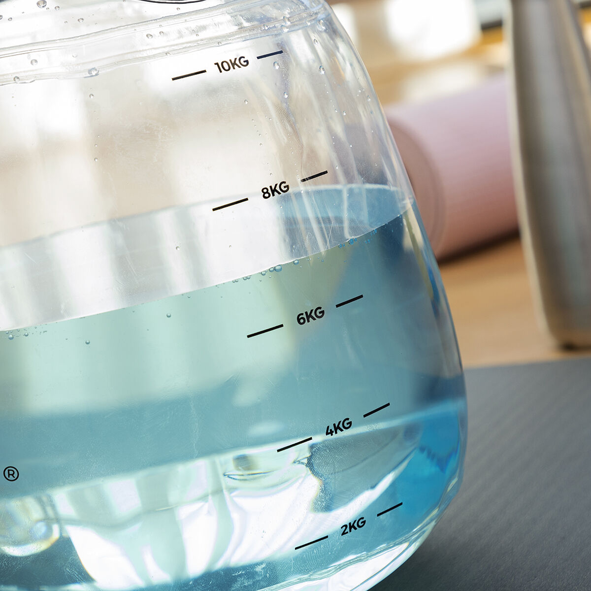 Watergevulde kettlebell voor fitnesstraining met oefengids